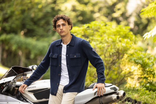 male model wearing navy cashmere shacket leaned against motorcycle