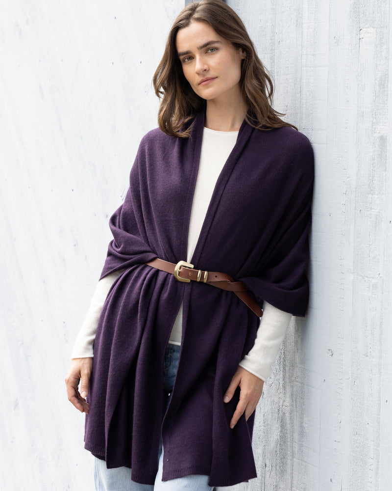 Woman standing in front of a barn wearing Kennedy Travel wrap with brown belt in Currant