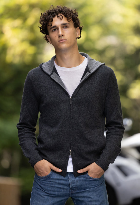 Man wearing cashmere hoodie in charcoal grey and denim pants